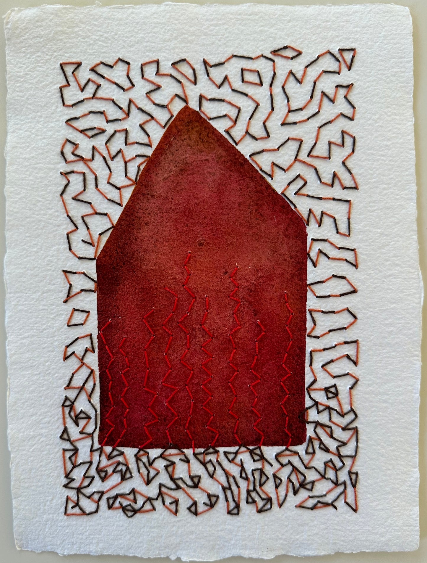 Fragments of Home #32, On Fire Again by Suzanne Gibbs, watercolor and Sashiko thread on paper, featuring a brick red house form with red stitched flames surrounded by dense black and rust stitching.