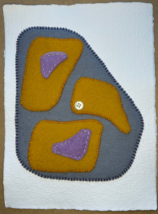 A piece of art featuring felt and thread work on handcrafted paper, with a visible button, by Suzanne Gibbs.