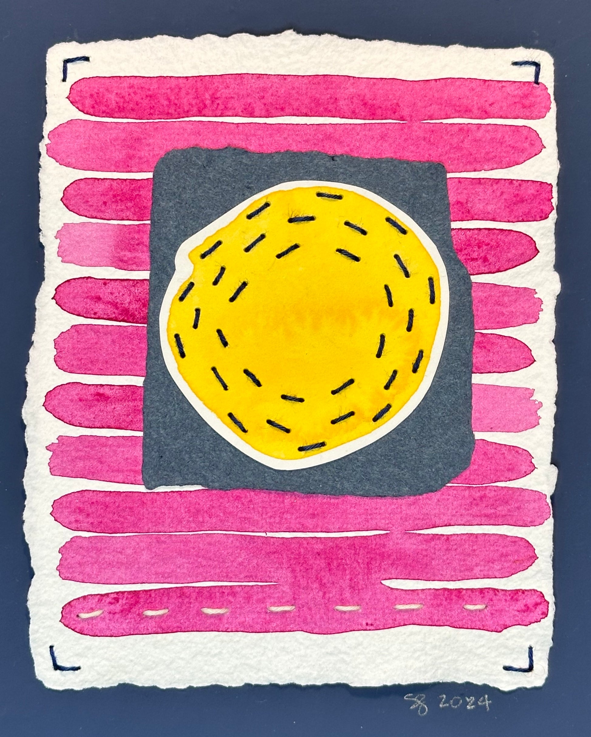 A piece of abstract art featuring a stitched quilted texture in pink, blue, and yellow colors, signed on the front by Suzanne Gibbs.