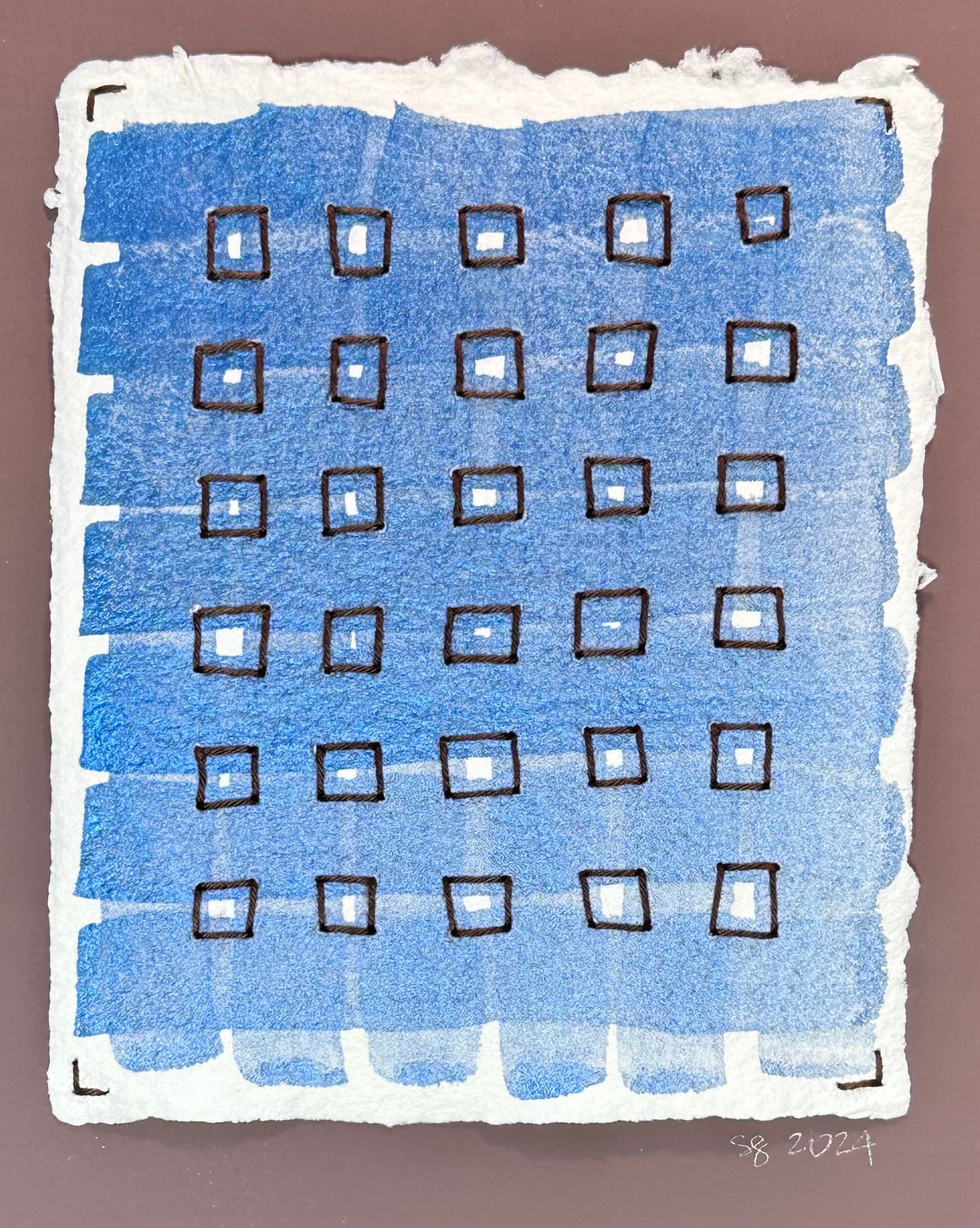 Mixed media artwork by Suzanne Gibbs from her Stitch & So series, created with watercolor paint and thread on handmade paper, featuring a plaid blue grid with brown stitched boxes.