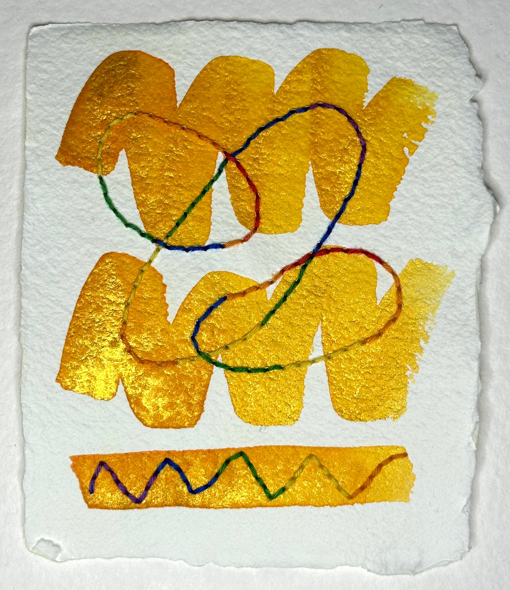 Abstract art made by Suzanne Gibbs with golden watercolor zig-zags and multi-colored variegated Sashiko thread on white handcrafted paper.