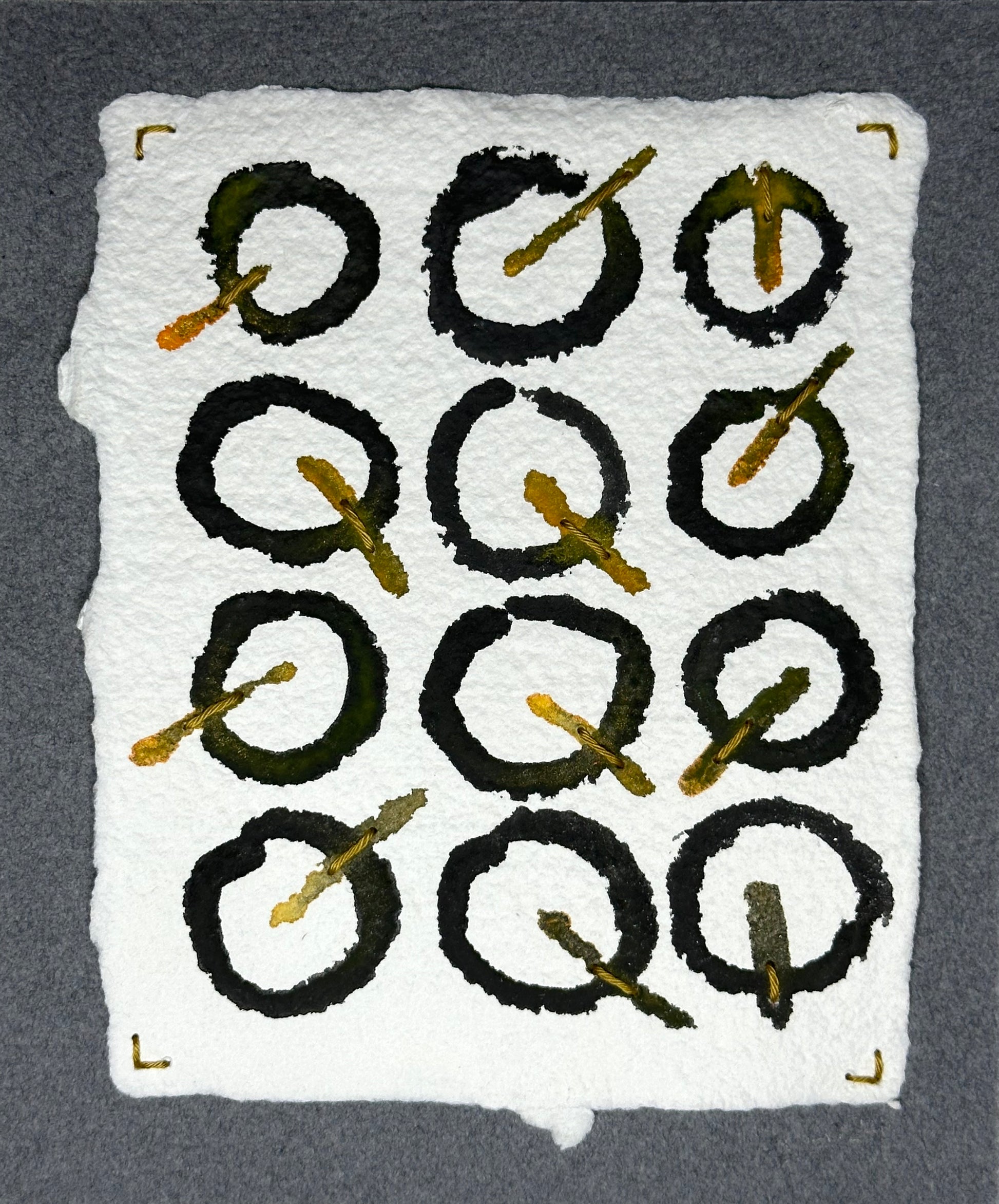 Mixed media artwork by Suzanne Gibbs from her Stitch & So series, created with watercolor paint and thread on handmade paper, featuring a grid of black circular forms with golden stitched lines suggesting clock hands on a white background.