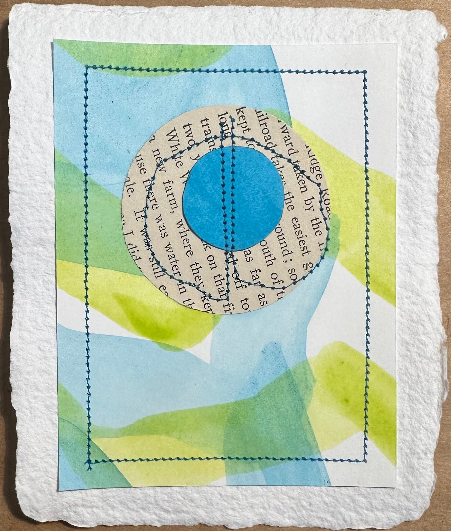 A piece of original art titled 'Stitch & So #68 Water Farm' featuring a collage of watercolor paints on handcrafted paper with a central book page design.
