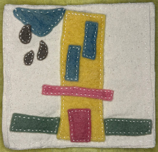 Fragments of Home textile art by Suzanne Gibbs with a tall yellow felt house, pink doorway, green base, blue windows, and dark raindrops beneath a blue cloud on a white fabric background, hand-stitched in white.