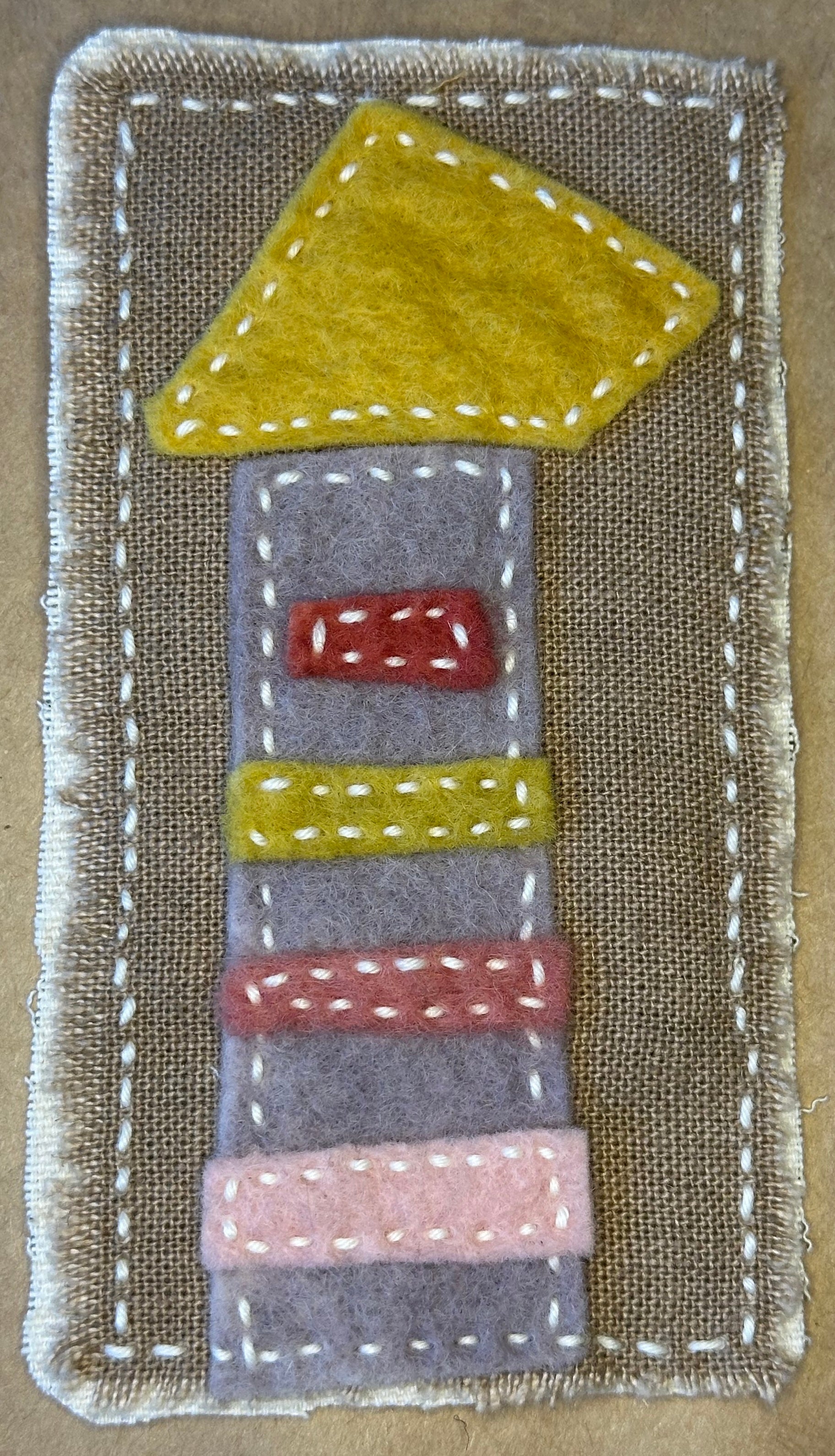 Textile artwork by Suzanne Gibbs of Portland, Oregon featuring a tower-like apartment building with a yellow roof.