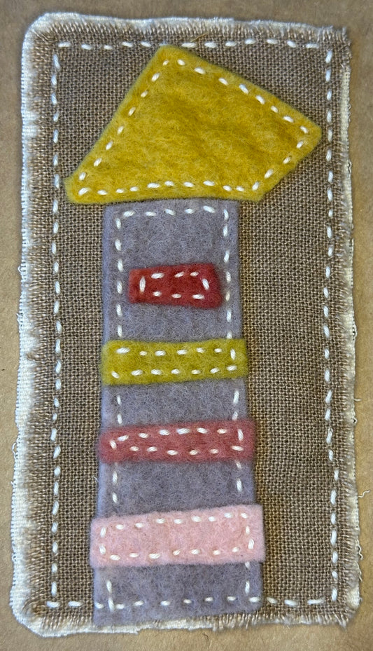 Textile artwork by Suzanne Gibbs of Portland, Oregon featuring a tower-like apartment building with a yellow roof.