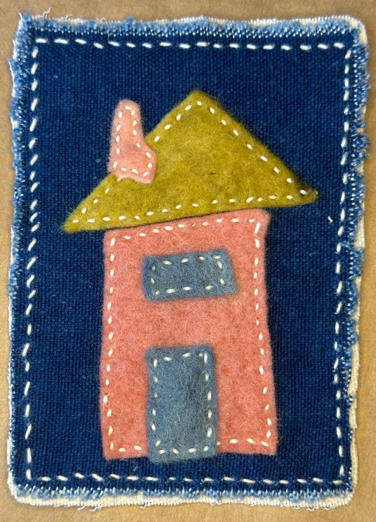 Textile artwork by Suzanne Gibbs from her Fragments of Home series, featuring a representation of her birth home on a deep blue background.
