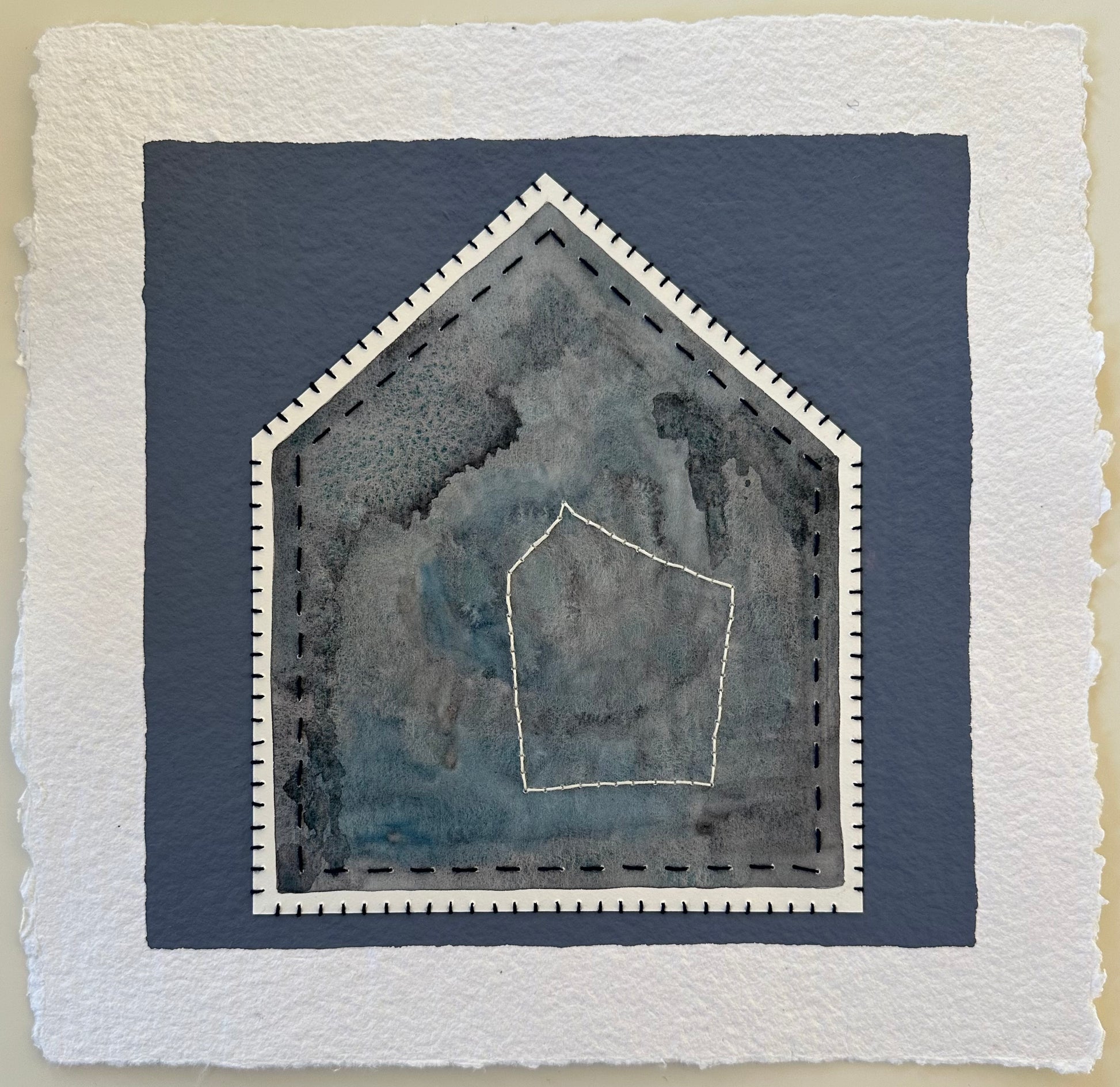 Fragments of Home #40, Heart of the Home by Suzanne Gibbs. A layered gray-blue house form with stitched outlines framing a smaller house shape at its center.