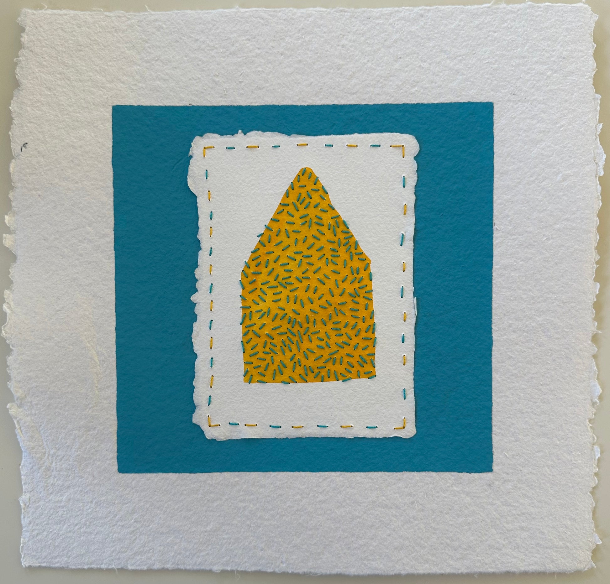 Fragments of Home #38, Not So Seedy by Suzanne Gibbs. A yellow house shape filled with teal stitches, layered on white paper and set against a teal ground.