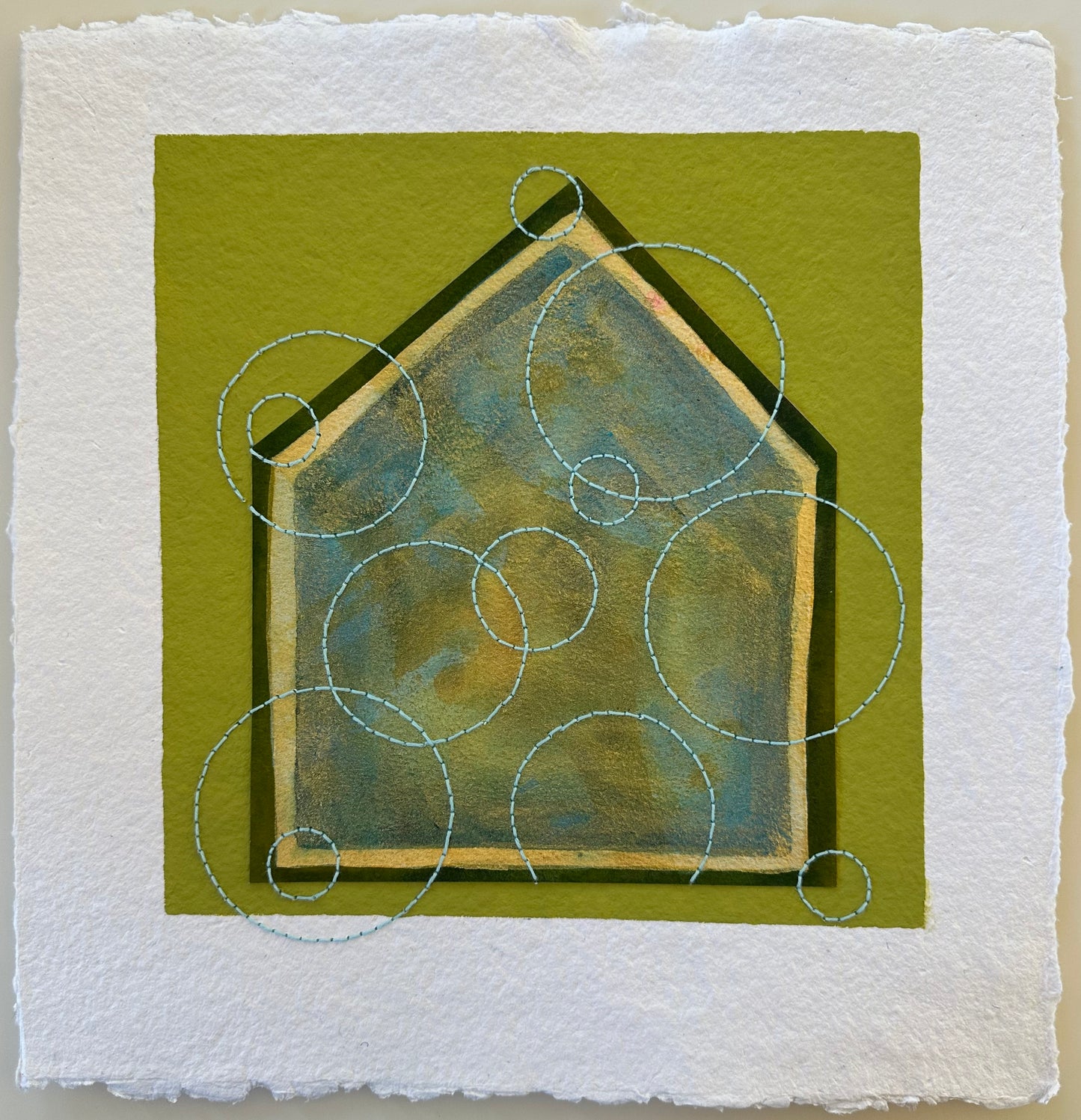 Fragments of Home #39, My Bubble by Suzanne Gibbs. A layered blue-green house form on olive paper, overlaid with stitched circular “bubble” shapes.