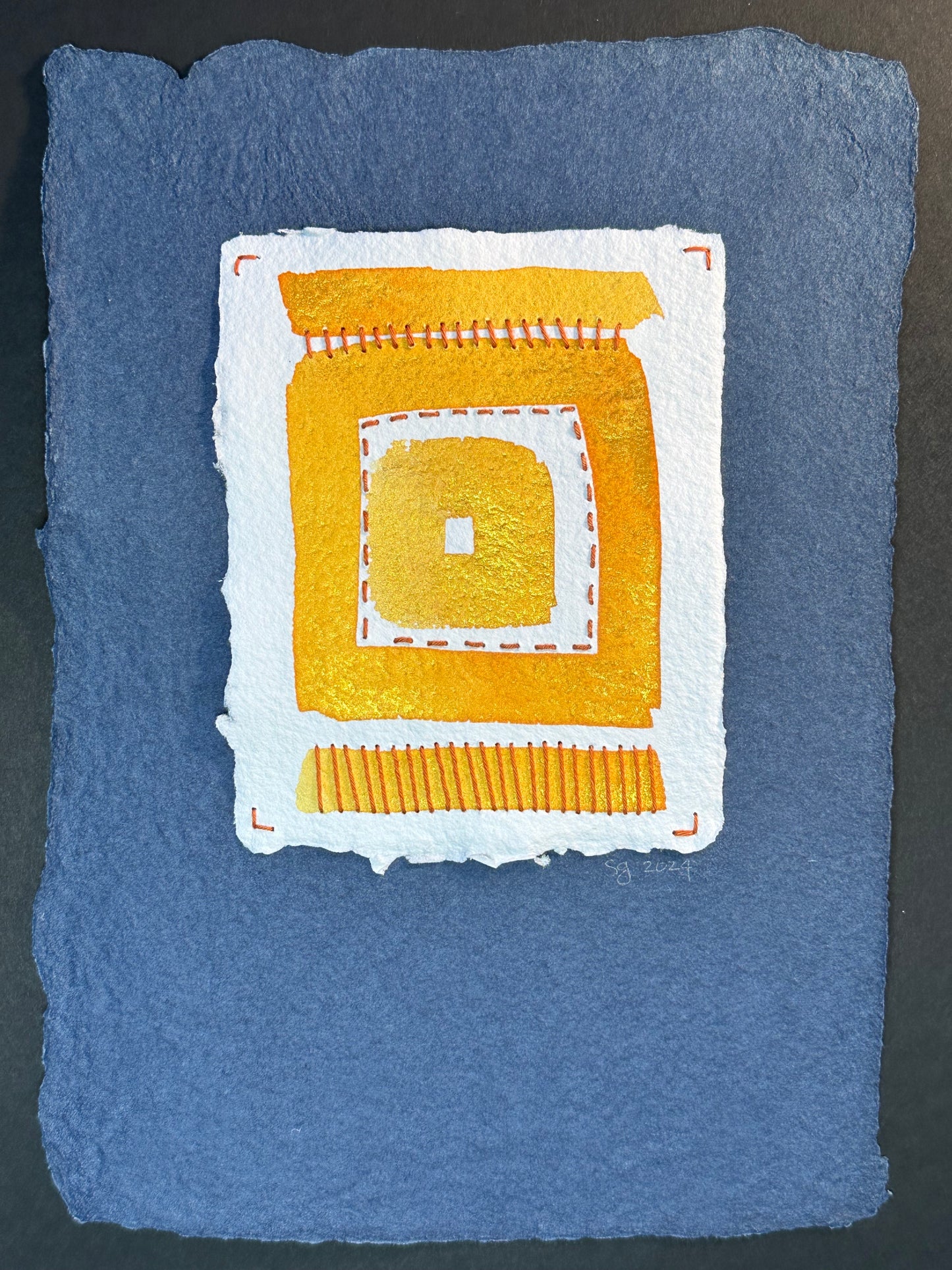 A watercolor painting featuring a bold geometric pattern with yellow and white on a blue handcrafted paper background, signed and dated by Suzanne Gibbs.