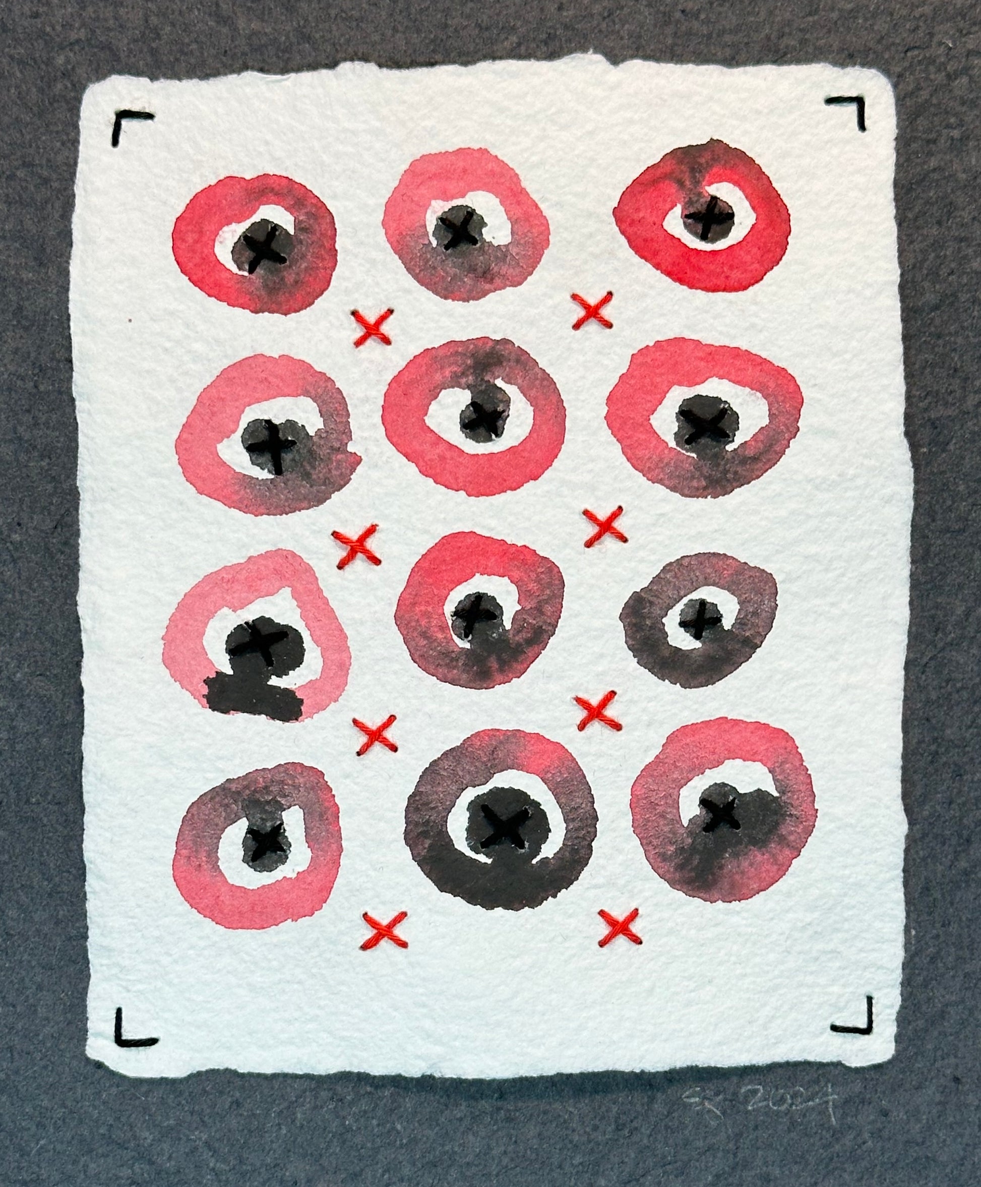 Mixed media artwork by Suzanne Gibbs from her Stitch & So series, created with watercolor paint and thread on handmade paper, featuring a grid of red circular forms with red and black stitched lines suggesting X's on a white background.