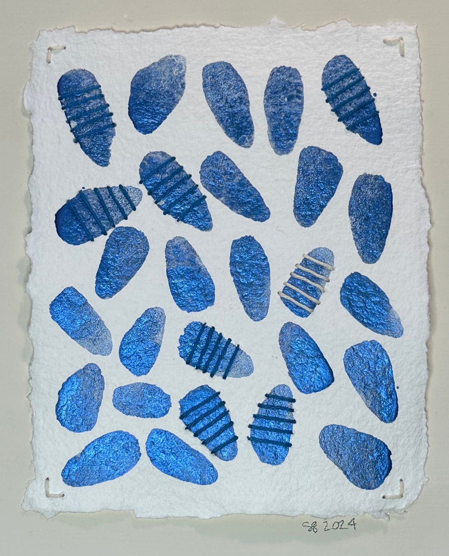 A watercolor painting by Suzanne Gibbs featuring a grid of blue petals, some stitched with Sashiko thread in a pattern on a white background.
