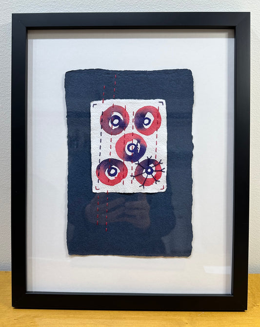 Mixed media artwork by Suzanne Gibbs from her Stitch & So series, created with watercolor paint and thread on handmade paper, featuring concentric circles with stitching over a deep blue background.