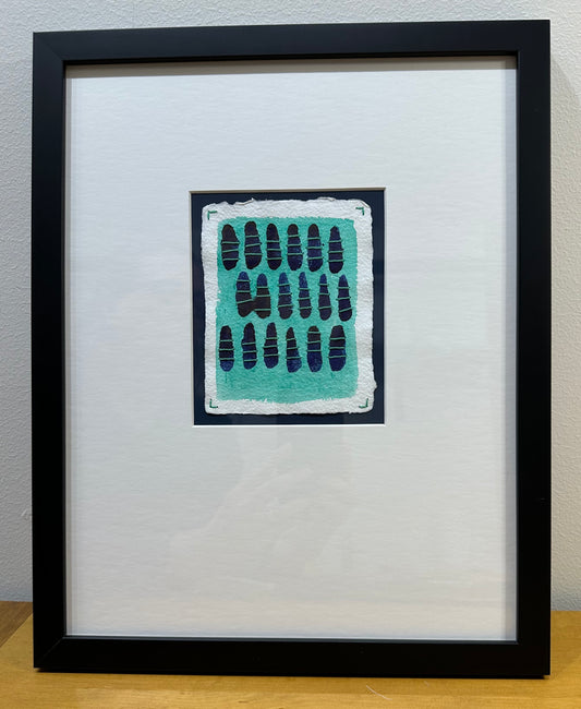 A framed watercolor painting titled 'Sometimes Twins' by Suzanne Gibbs, featuring an abstract pattern with blue paint and green sashiko stitches on a white background, signed and dated on the front.